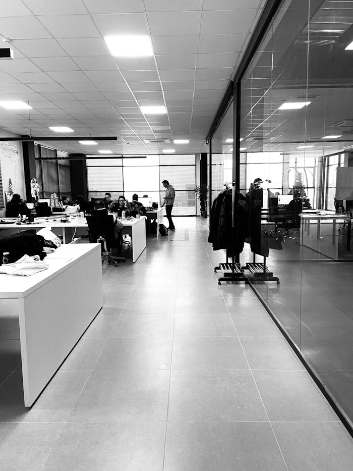 pexels-photo-3415148 Black and white of anonymous employees working together in modern office with glass walls